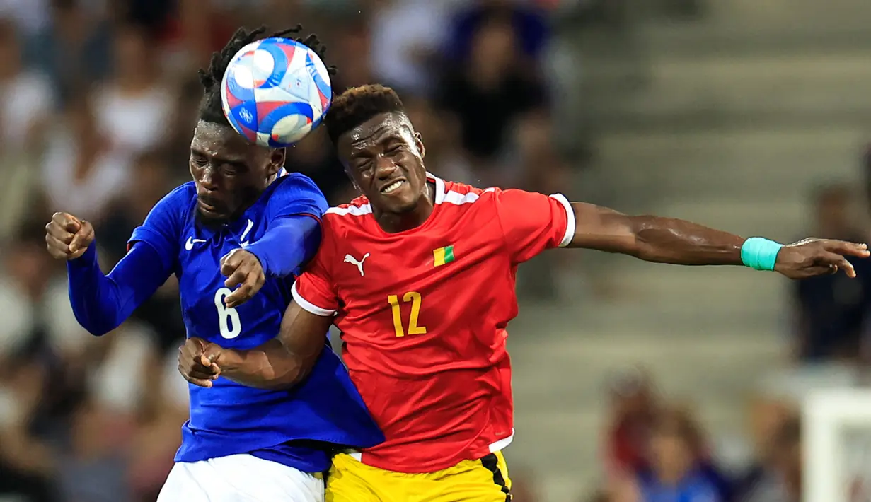 Gelandang Prancis #06 Manu Kone (Kiri) berebut bola dengan penyerang Guinea #12 Algassime Bah pada matchday 2 Grup A sepak bola Olimpiade Paris 2024 di stadion Allianz Riviera, Minggu (28/7/2024). (Valery HACHE / AFP)