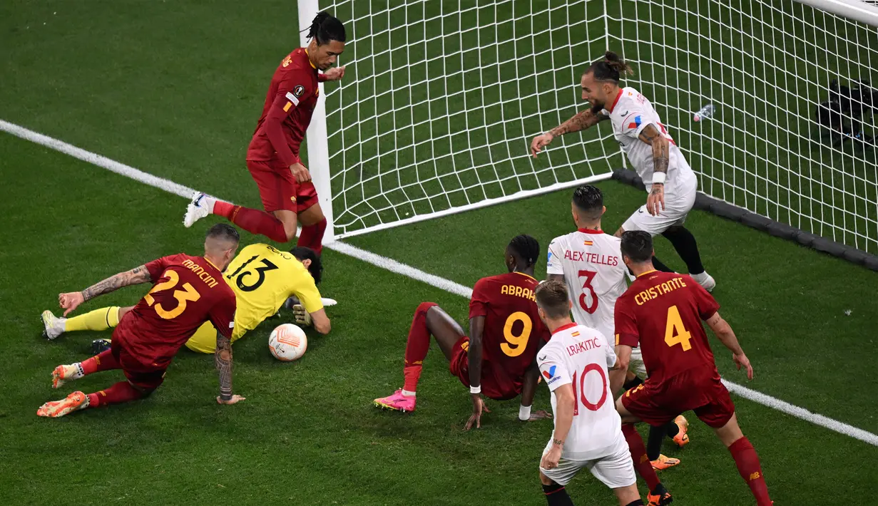 Kiper Sevilla, Yassine Bounou (dua kiri), berhasil menggagalkan kemelut di depan gawangnya dari serangan pemain AS Roma pada laga final Liga Europa 2022/2023 yang berlangsung di Puskas Arena, Budapest, Kamis (1/6/2023) dini hari WIB. (AFP/Ferenc Isza)