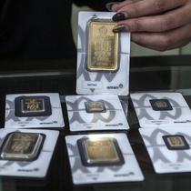 Pramuniaga menunjukkan emas batangan PT Aneka Tambang (Antam) Tbk di sebuah gerai emas, Jakarta, Senin (18/1/2021). Pada hari ini, harga emas Antam turun menjadi Rp 944 ribu per gram. (Liputan6.com/Johan Tallo)