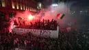 Ribuan penggemar bersorak saat bus yang membawa para pemain tim sepak bola AC Milan melakukan parade kemenangan Liga Italia di depan Katedral Gotik Milan, Milan, Italia, 23 Mei 2022. (AP Photo/Luca Bruno)