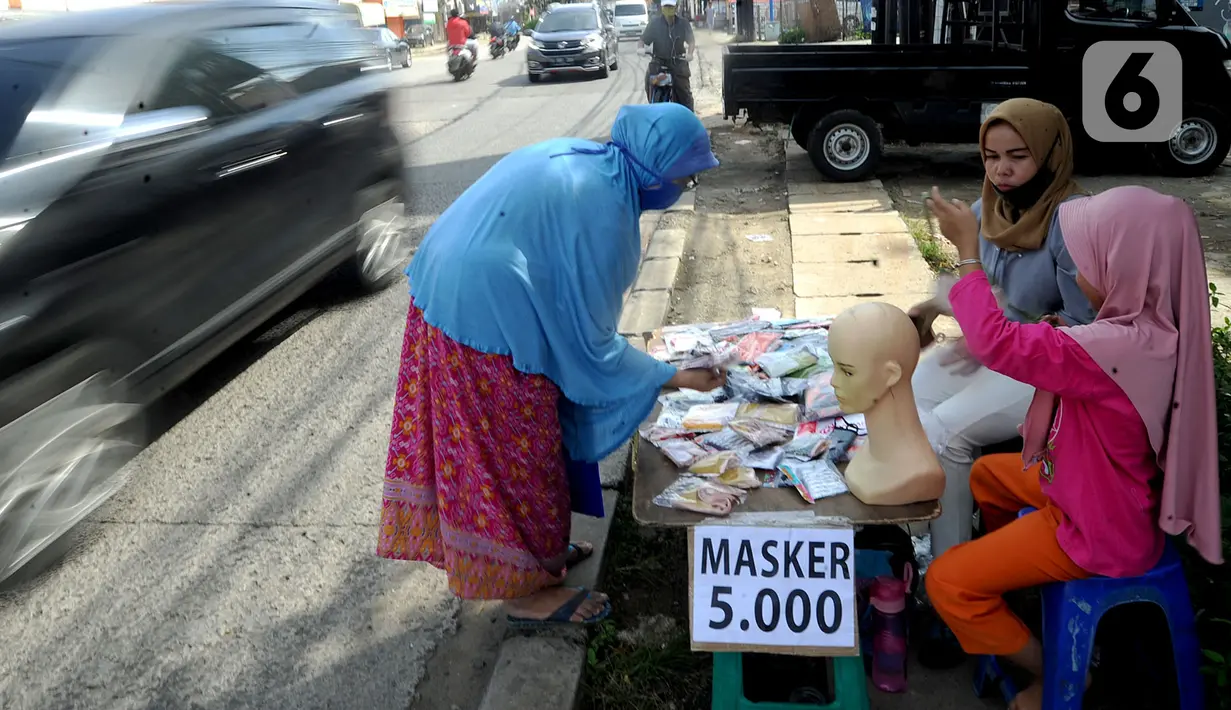 Seorang ibu ditemani anaknya melayani pembeli saat berjualan masker kain buatan rumahan di Jalan Raya Cinere-Depok, Limo, Depok, Rabu (8/4/2020). Dalam sehari ia  mampu menjual rata-rata 300 masker kain. (merdeka.com/Arie Basuki)