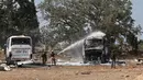 Seorang petugas pemadam kebakaran Israel memadamkan bangkai bus di lokasi jatuhnya rudal Iran di sebuah depot bus di Herzliya dekat Tel Aviv pada 17 Juni 2025. (Jack GUEZ/AFP)