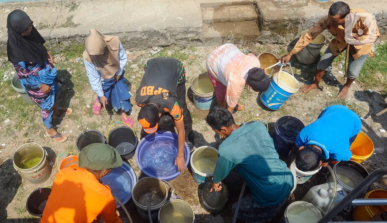 Penyaluran air bersih kepada warga Desa Weninggalih diawasi oleh petugas BPBD Kabupaten Bogor dan polisi dari Polsek Jonggol. (merdeka.com/Arie Basuki)