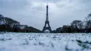 Foto yang diambil di Champ de Mars di Paris pada tanggal 9 Januari 2024, menunjukkan ruang terbuka hijau publik yang luas yang tertutup salju dan Menara Eiffel. (Ludovic MARIN/AFP)