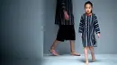 Model cilik berjalan di atas catwalk mengenakan koleksi busana orang tua dan anak YIAN karya Lu Enhua selama China Fashion Week di Beijing, Sabtu 1 April 2017. (AP Photo / Mark Schiefelbein)