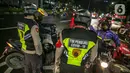 Polisi memberi arahan kepada pengendara motor saat penyekatan jalan di kawasan Pasar Baru, Jakarta, Kamis (31/12/2020). Polda Metro Jaya menutup sejumlah ruas jalan selama Car Free Night dan Crowd Free Night pada malam Tahun Baru 2021 untuk mencegah penyebaran COVID-19. (Liputan6.com/Faizal Fanani)