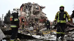 Serangan tersebut terjadi jelang peringatan peringatan empat tahun invasi militer Rusia ke Ukraina. Tampak dalam foto, tim penyelamat Ukraina bekerja di lokasi rumah yang rusak parah akibat serangan udara di Sofiivska Borshchagivka, wilayah Kyiv pada Minggu 22 Februari 2026. (Henry NICHOLLS/AFP)