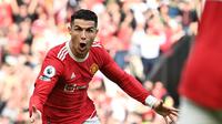 Striker Manchester United Cristiano Ronaldo merayakan gol ketiganya ke gawang Norwich City dalam pertandingan Liga Inggris di Old Trafford, Sabtu (16/4/2022). MU menang 3-2 berkat hattrick Ronaldo. (Paul ELLIS / AFP)