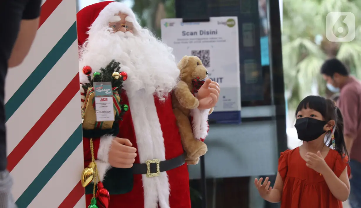 Seorang anak melintas di samping pernak pernik Natal di Living World, Tangerang Selatan, Senin (13/12/2021). Jelang perayan Natal sejumlah pusat perbelanjaan dihiasi ornamen Natal yang dijual. (Liputan6.com/Anga Yuniar)