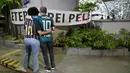 Dua orang berdiri di depan spanduk bertuliskan "Raja Abadi Pele" di luar Rumah Sakit Israel Albert Einstein, tempat legenda sepak bola Brasil itu meninggal setelah lama berjuang melawan kanker di Sao Paulo, Brasil, pada 29 Desember 2022. (AFP/Miguel Schincariol)