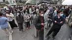 Warga menunggu di luar gedung perkantoran setelah gempa mengguncang Jakarta, Jumat (14/1/2022). Gempa magnitudo 6,7 yang berpusat di Banten pada pukul 16.05 WIB membuat kepanikan di berbagai daerah. (AP Photo)