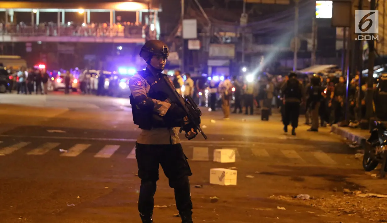 Polisi berjaga di sekitar Terminal Kampung Melayu, Jakarta, Rabu (24/5). Warga sekitar tampak berkerumun untuk melihat lokasi ledakan. (Liputan6.com/Angga Yuniar)