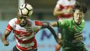 Striker Madura United, Greg Nwokolo, berebut bola dengan gelandang PS TNI, Soonhak Hong, pada laga Liga 1 Indonesia di Stadion Pakansari, Bogor, Senin (18/9/2017). Madura United menang 3-2 atas PS TNI. (Bola.com/M Iqbal Ichsan)