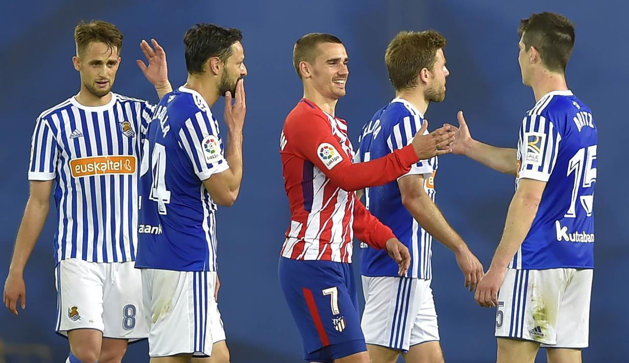 Striker Atletico Madrid, Antoine Griezmann, bersalaman dengan para pemain Real Sociedad pada laga La Liga di Stadion Municipal de Anoeta, Kamis (19/4/2018). Real Sociedad menang 3-0 atas Atletico Madrid. (AFP/Ander Gillenea)