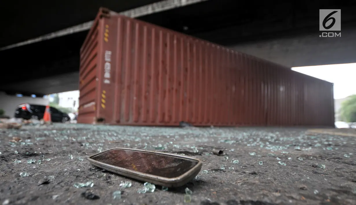 Kaca spion tergeletak di dekat kontainer pasca kecelakaan di kolong flyover Tomang, Jakarta, Kamis (28/6). Kecelakaan tersebut diduga akibat truk kelebihan muatan dan beruntung sang sopir hanya mengalami luka ringan. (Merdeka.com/Iqbal S. Nugroho)