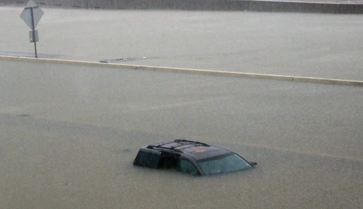 Sebuah kendaraan yang ditinggalkan pemiliknya terendam banjir setelah Badai Harvey menghantam kota Houston, Texas, Minggu (27/8). Hingga saat ini, korban tewas dikonfirmasi jumlahnya mencapai 2 orang. (AP/LM Otero)