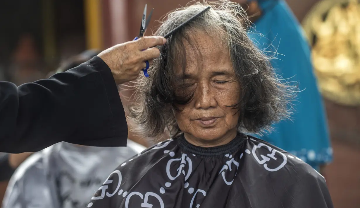 Warga saat potong rambut gratis di Masjid Muhammad Cheng Hoo, Surabaya, Jawa Timur, Senin (18/4/2022). Kegiatan berbagi dalam bulan Ramadhan yang digelar Baksose Suroboyo dan Ngaji Komunitas Salon (Ngasal) Surabaya itu diikuti sekitar 450 orang. (AFP/Juni Kriswanto)