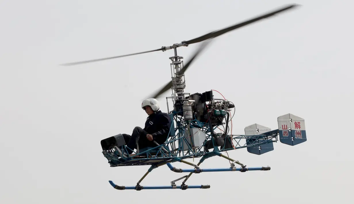 Pria 60 tahun bernama Guo Leiting saat terbang menggunakan helikopter buatannya sendiri di Yuncheng , provinsi Shanxi , Cina, 21 April 2016. Meskipun tinggal di desa dengan bahan seadanya, Ia mampu membuat helikopter. (REUTERS / Stringer)