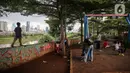 Sejumlah anak bermain di taman bermain yang terdapat di Bantaran Banjir Kanal Barat Kawasan Petamburan, Jakarta, Minggu (12/12/2021). Minimnya taman bermain di pemukiman padat penduduk membuat anak-anak seringkali bermain di tempat yang tidak semestinya. (Liputan6.com/Faizal Fanani)
