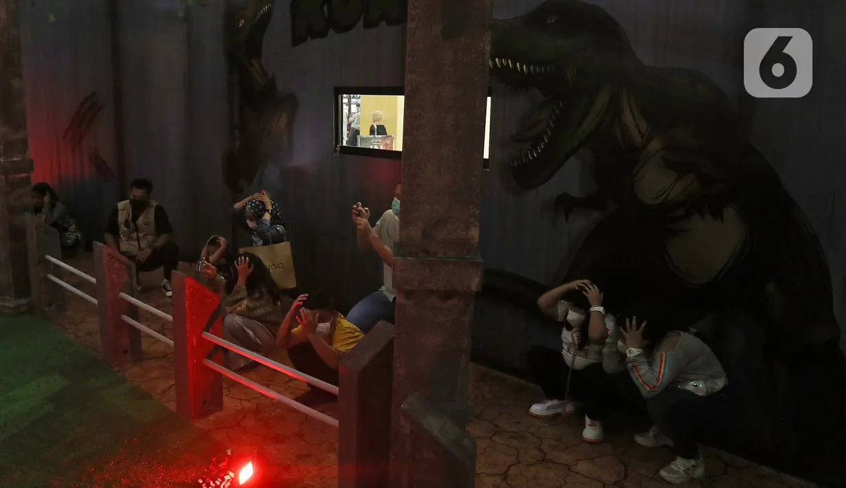 Pengunjung menyaksikan replika hewan prasejarah dalam wahana Dino Factory by Dino Island di Mal Kota Kasablanka, Jakarta, Jumat (17/12/2021). Wahana juga menjadi sarana edukasi pengetahuan tentang hewan-hewan prasejarah kepada para pengunjung. (Liputan6.com/Herman Zakharia)