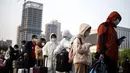 Warga yang mengenakan masker hingga pakaian pelindung tiba di Stasiun Hankou, Wuhan, Hubei, China, Rabu (8/4/2020). Setelah pandemi virus corona COVID-19 mereda, banyak warga di Wuhan beraktivitas memakai masker, sarung tangan, pelindung wajah, hingga pakaian pelindung. (NOEL CELIS/AFP)