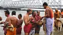 Umat Hindu melakukan ritual 'Tarpan' pada hari Pitrupaksh di Sungai Gangga di Kolkata (19/9). Hari Pitrupaksh menggambarkan hari ketika para dewa menciptakan dewi dewi untuk menghancurkan raja setan Asura. (AFP Photo/Dibyangshu Sarkar)