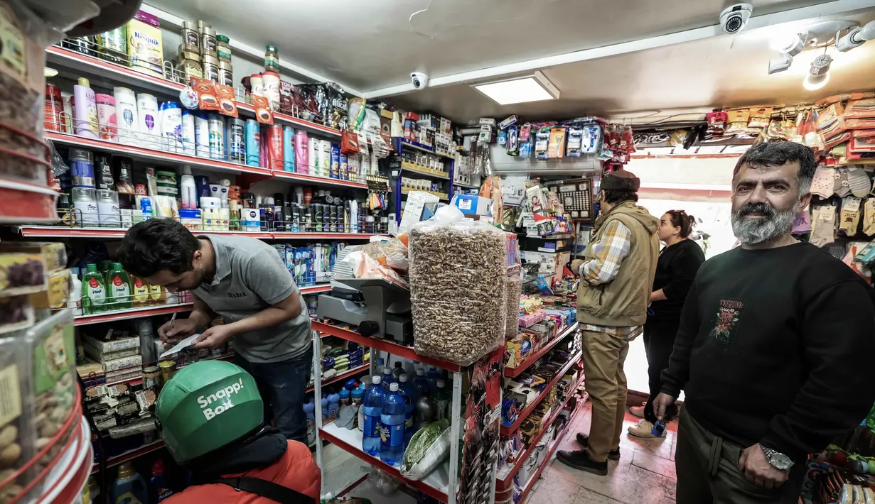 Amerika Serikat dan Israel melancarkan serangan terhadap Iran pada Sabtu 28 Februari 2026. Tampak dalam foto, orang-orang berbelanja bahan makanan di sebuah toko di Teheran, Iran pada Sabtu 28 Februari 2026. (Atta KENARE/AFP)