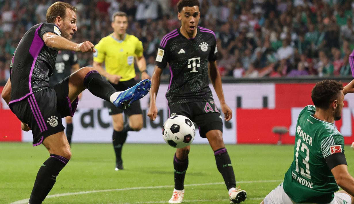 Pemain Bayern Munchen, Harry Kane (kiri), menendang bola yang mampu dihalau pemain Werder Bremen dalam pertandingan perdana Liga Jerman 2023/2024 yang berlangsung di Wohninvest Weserstadion, Jerman, Sabtu (19/8/2023) dini hari WIB. (AFP/Ina Fassbender)