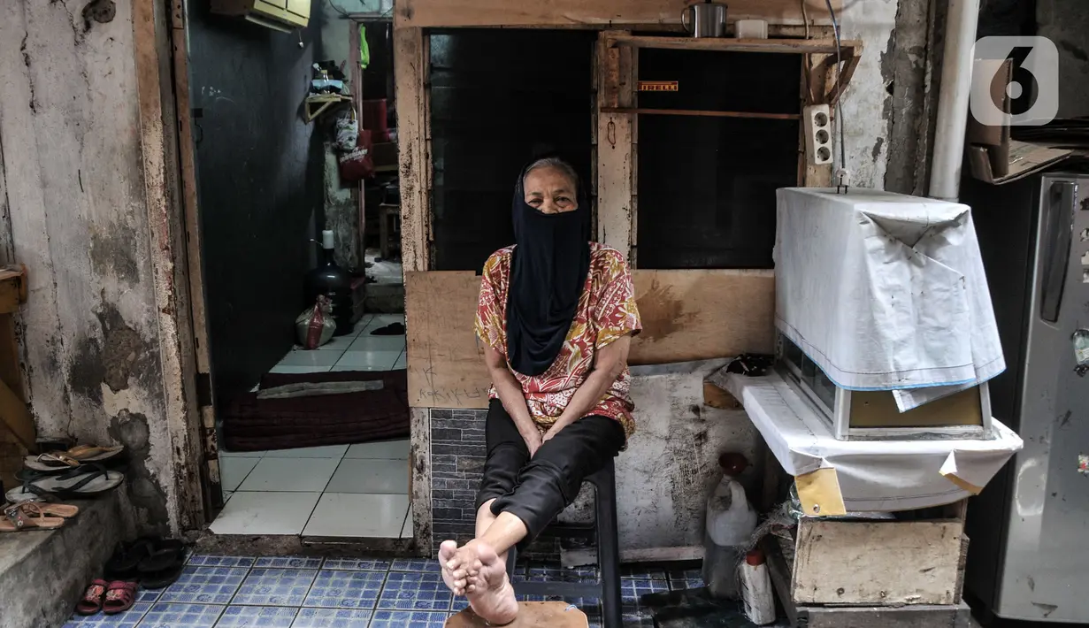 Warga duduk depan rumah saat pemberlakuan karantina mikro (mikro lockdown) di RW 002, Kelurahan Krukut, Taman Sari, Jakarta Barat, Senin (10/1/2022). Selain mikro lockdown, petugas melakukan tes massal kepada warga setempat guna mencegah penularan COVID-19 lebih luas. (merdeka.com/Iqbal S. Nugroho)