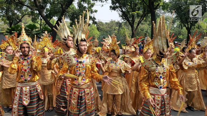 Peserta dengan menggunakan pakaian tradisional turut meramaikan pawai obor Asian Para Games 2018 di Jakarta, Minggu (30/9). Asian Para Games akan dilaksanakan pada 6-13 Oktober 2018 mendatang. (Liputan6.com/Herman Zakahria)