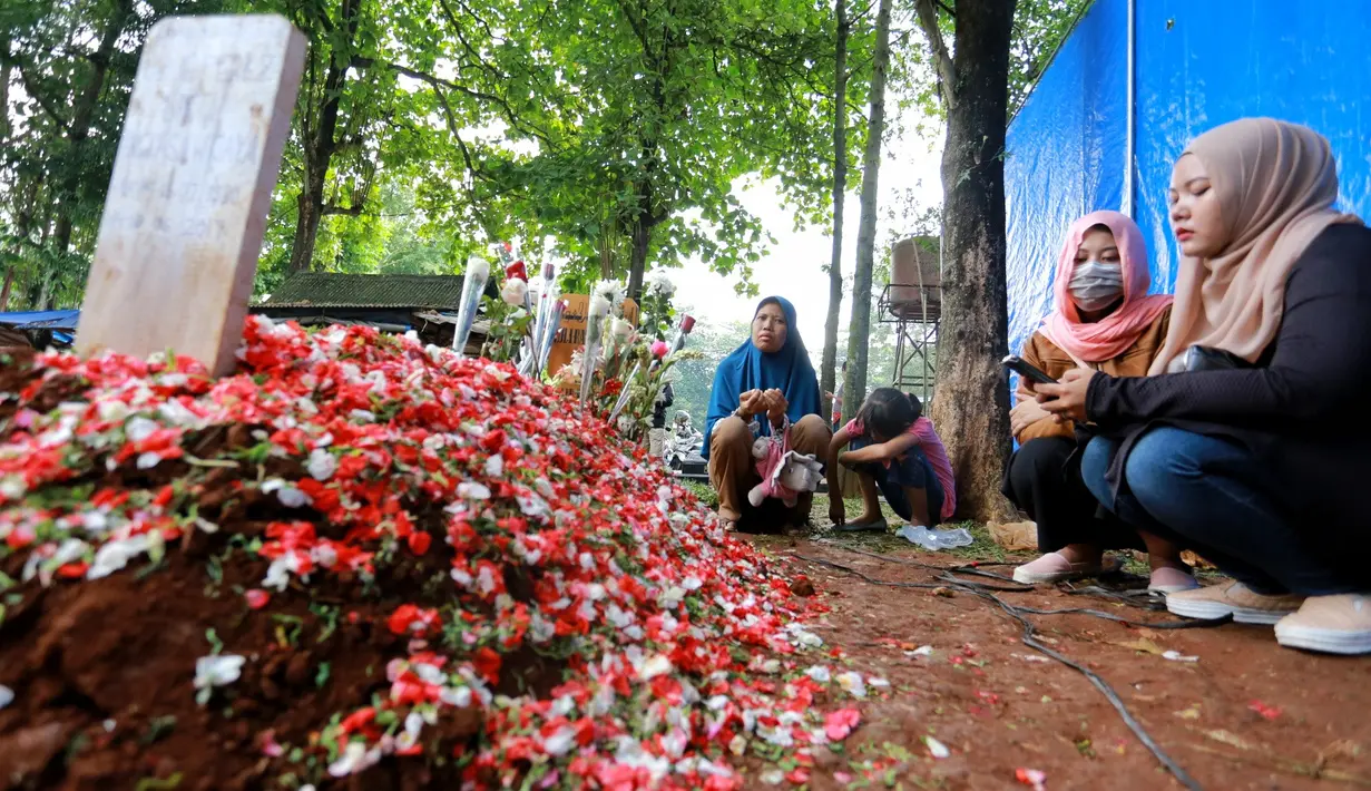 Tanah merah di atas makam mendiang Jupe bisa dibilang masih basah. Para penggemar Jupe yang datang dari berbagai daerah turut berdatangan guna melihat dan memanjatkan doa di tepi pusara Jupe. (Adrian Putra/Bintang.com)