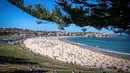 Orang-orang mengunjungi pantai Bondi di Sydney, Australia pada 5 Oktober 2020. Kerumunan warga dan aktivitas yang ramai ini membuat penerapan jarak sosial menjadi nyaris mustahil dilakukan.  (Photo by DAVID GRAY / AFP)