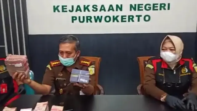 Kajari Purwokerto, Sunarwan, (kiri) menunjukkan barang bukti uang tunai Rp 470 juta yang disita dari rumah seorang saksi kasus dugaan korupsi dana JPS Kemenaker. (Foto: Liputan6.com/Kejari Purwokerto)
