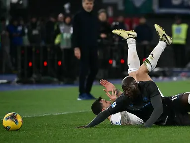 Pemain Napoli, Romelu Lukaku berebut bola dengan pemain Lazio, Alessio Romagnoli dalam laga lanjutan Liga Italia 2024/2025 di Olympic Stadium, Roma, Italia, Minggu (16/02/2025) WIB. (AFP/Filippo Monteforte)