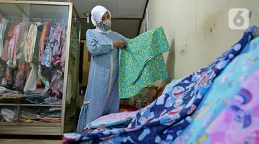 Penjahit sedang melihat bahan di kawasan Cipinang Cempedak, Jakarta, Kamis (18/6/2020). Kreasi penutup kepala, masker dan Gown yang di inisiasi oleh seorang dokter di RSIA Tambak yang di design untuk khusus tema anak saat masa Pandemi  COVID-19. (Liputan6.com/Herman Zakharia)