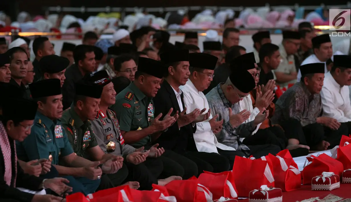 Presiden Joko Widodo dan Wapres Jusuf Kalla berdoa saat menghadiri acara buka puasa bersama dengan Panglima TNI Jenderal Gatot Nurmantyo dan para prajurit TNI di Mabes TNI, Cilangkap, Jakarta Timur, Senin (19/6). (Liputan6.com/Angga Yuniar)