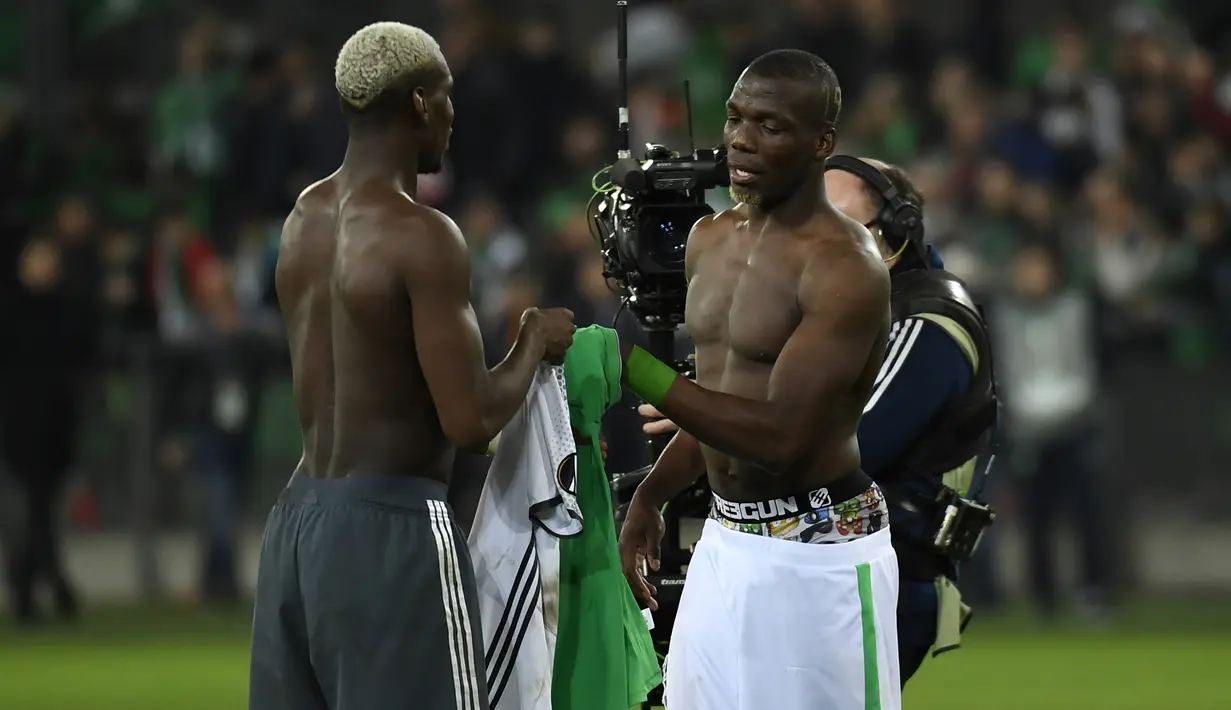 Gelandang Manchester United Paul Pogba (kiri) dan bek Saint-Etienne Florentin Pogba saling bertukar jersey usai pertandingan Liga Europa antara Manchester United melawan Saint-Etienne, di Stade Geoffroy-Guichard, Rabu (22/2). (PHILIPPE DESMAZES/AFP)