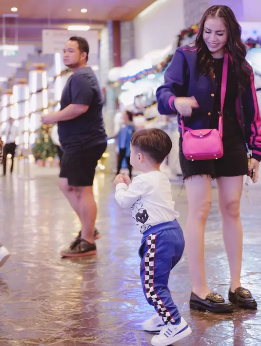 Satu lagi potret cantik dan stylish Momo Geisha saat momong anak. Ia tampil dengan mengenakan tank top hitam yang dilapisinya dengan jaket berwarna biru navy-ungu, denim short pants hitam, dan sneakers. Foto: Instagram.
