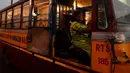 Pratima Poddar saat menunggu penumpang di Kolkata, India (8/3). Pratima Poddar 42 tahun merupakan satu-satunya sopir bus umum perempuan di Kolkata. (AFP Photo/Dibyangshu Sarkar)