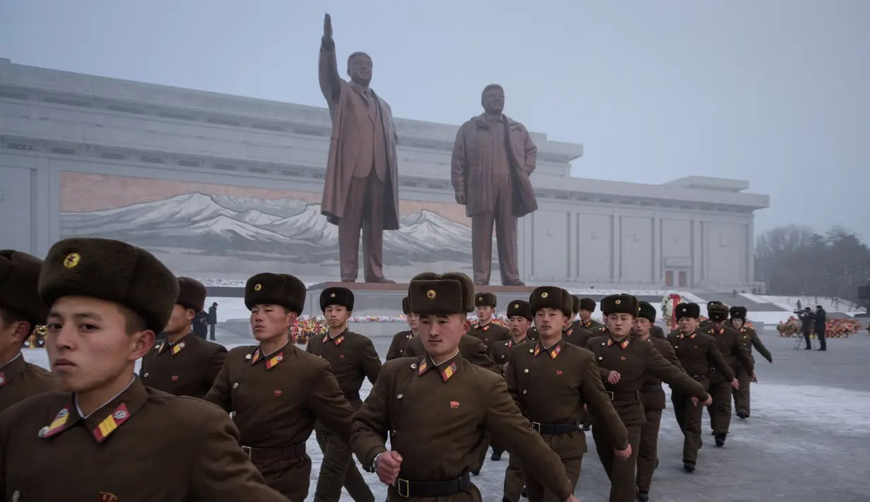 Tentara Korut usai memberi hormat untuk patung pemimpin Korea Utara Kim Il Sung dan Kim Jong Il selama Hari Peringatan Nasional di Bukit Mansu, Pyongyang (17/12).  Korea Utara tengah memperingati 7 tahun wafatnya  Kim Jong Il. (AFP Photo/Kim Won Jin)