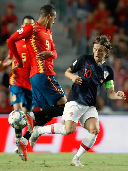 Gelandang Kroasia, Luka Modric berebut bola dengan dengan penyerang Spanyol, Rodrigo Moreno selama pertandingan UEFA Nations League di stadion Manuel Martinez Valero, Spanyol (11/9). Spanyol menang 6-0 atas Kroasia. (AP Photo/Alberto Saiz)