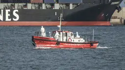 Kapal pesiar MV Hondius dilarang bersandar oleh otoritas setempat untuk mencegah penyebaran virus ke penduduk lokal. Tampak dalam foto, sebuah kapal ambulans yang membawa awak yang mengenakan pakaian pelindung bahan berbahaya (hazmat suit) kembali ke pelabuhan Praia, ibu kota Tanjung Verde, pada 5 Mei 2026 setelah mengunjungi kapal pesiar MV Hondius, yang sedang berlabuh di lepas pelabuhan. (Foto oleh AFP)
