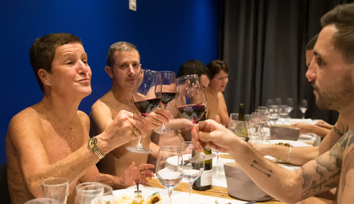 Pengunjung bersulang sambil telanjang saat menikmati hidangan di restoran O'naturel yang baru dibuka di Paris, 5 Desember 2017. Restoran O'naturel merupakan restoran nudis (telanjang) pertama di ibu kota Prancis. (GEOFFROY VAN DER HASSELT / AFP)