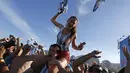 Seorang wanita tampak digendong di pundak seorang pria sambil melemparkan kaos tim Argentina di pantai Copacabana, Brasil, Sabtu (5/7/14). (REUTERS/Pilar Olivares)