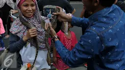 Pencinta reptil yang tergabung dalam Reptile dan Amphibian Community menampilkan beberapa hewan reptil mereka di Car Free Day, Jakarta, Minggu (23/8/2015). Kehadiran mereka menarik perhatian warga yang sedang menikmati CFD. (Liputan6.com/Johan Tallo)