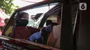 Petugas saat pelaksanaan vaksinasi COVID-19 secara drive-thru kepada warga di Mapolres Jakarta Selatan, Selasa (29/6/2021). Polres Metro Jakarta Selatan membuka gerai vaksin presisi dengan menyediakan layanan vaksin COVID-19 gratis kepada warga ber-KTP Jakarta Selatan. (Liputan6.com/Faizal Fanani)