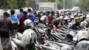 Ratusan motor terparkir di jalur cepat Jalan Tegar Beriman Kab Bogor, Selasa (13/12). Ribuan calon suporter Timnas Indonesia antre membeli tiket laga final pertama di halaman Kodim 0621 Surya Kancana. (Liputan6.com/Helmi Fithriansyah)