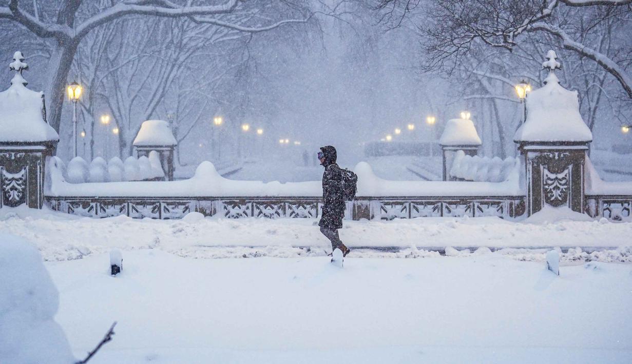 Wali Kota New York, Zohran Mamdani, juga menyatakan status darurat dan larangan bepergian telah diberlakukan mulai pukul 21.00 pada Minggu (22/2/2026) hingga pukul 12.00 pada Senin (23/2/2026) waktu setempat. Tampak dalam foto, seorang komuter berjalan melalui Central Park di Kota New York, pada Senin 23 Februari 2026. (Ryan Murphy/Getty Images North America/Getty Images via AFP)