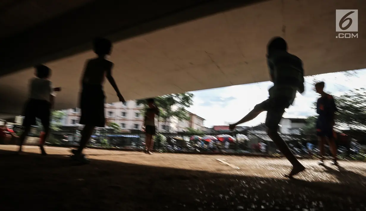 Anak-anak bermain sepak bola di kolong jembatan layang Tanah Abang, Jakarta, Kamis (15/11). Mereka memanfaatkan lahan kosong usai jam pulang sekolah. (Liputan6.com/Fery Pradolo)