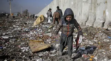 Seorang anak Afghanistan yang kehilangan tempat tinggalnya mencari barang-barang plastik dan lainnya yang dapat digunakan sebagai pengganti kayu bakar, di tempat pembuangan sampah di Kabul, Afghanistan (15/12/2019). (AP Photo/Altaf Qadri)